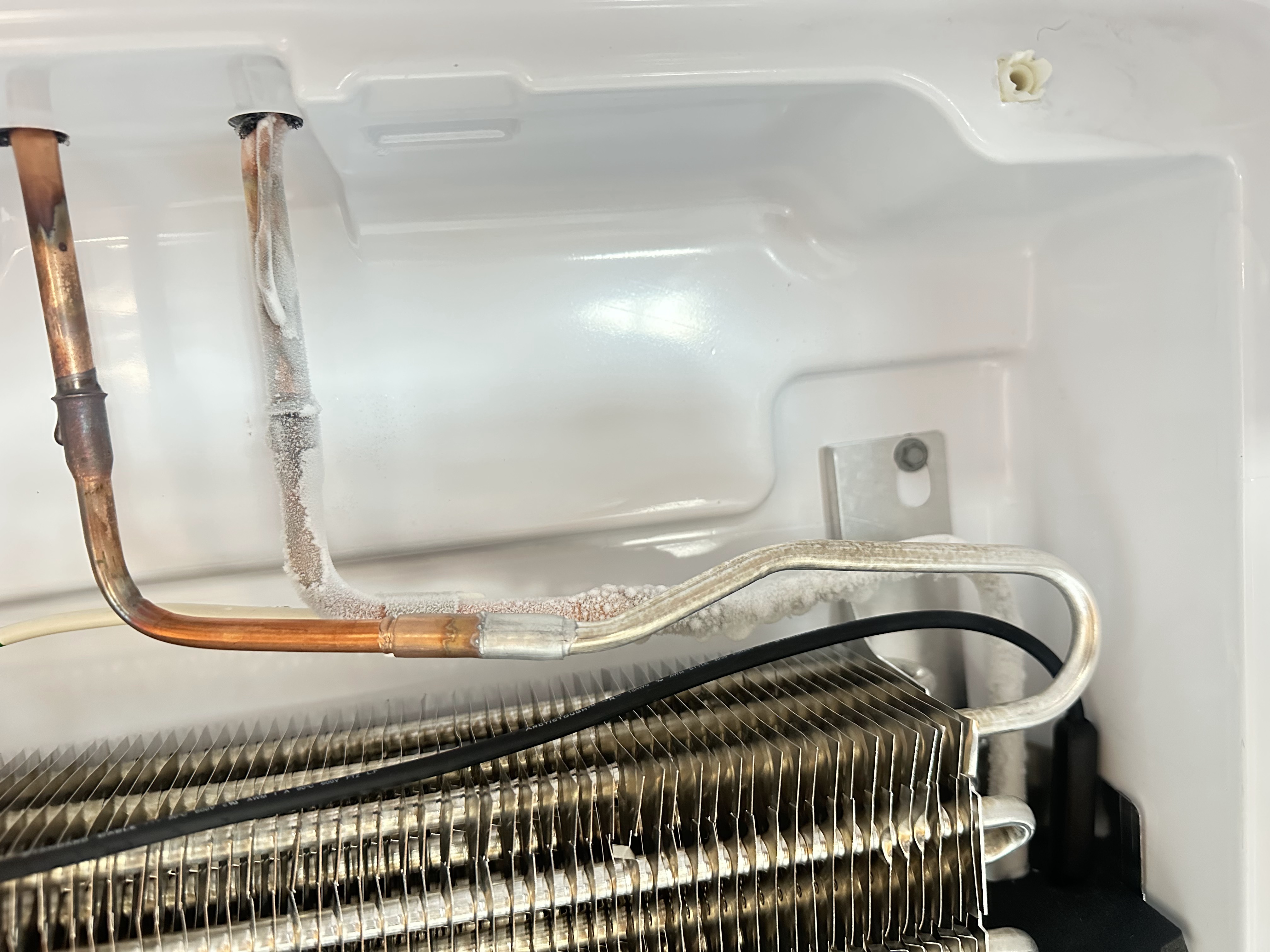 Frost buildup on GE refrigerator evaporator tubing caused by sealed system cooling issues