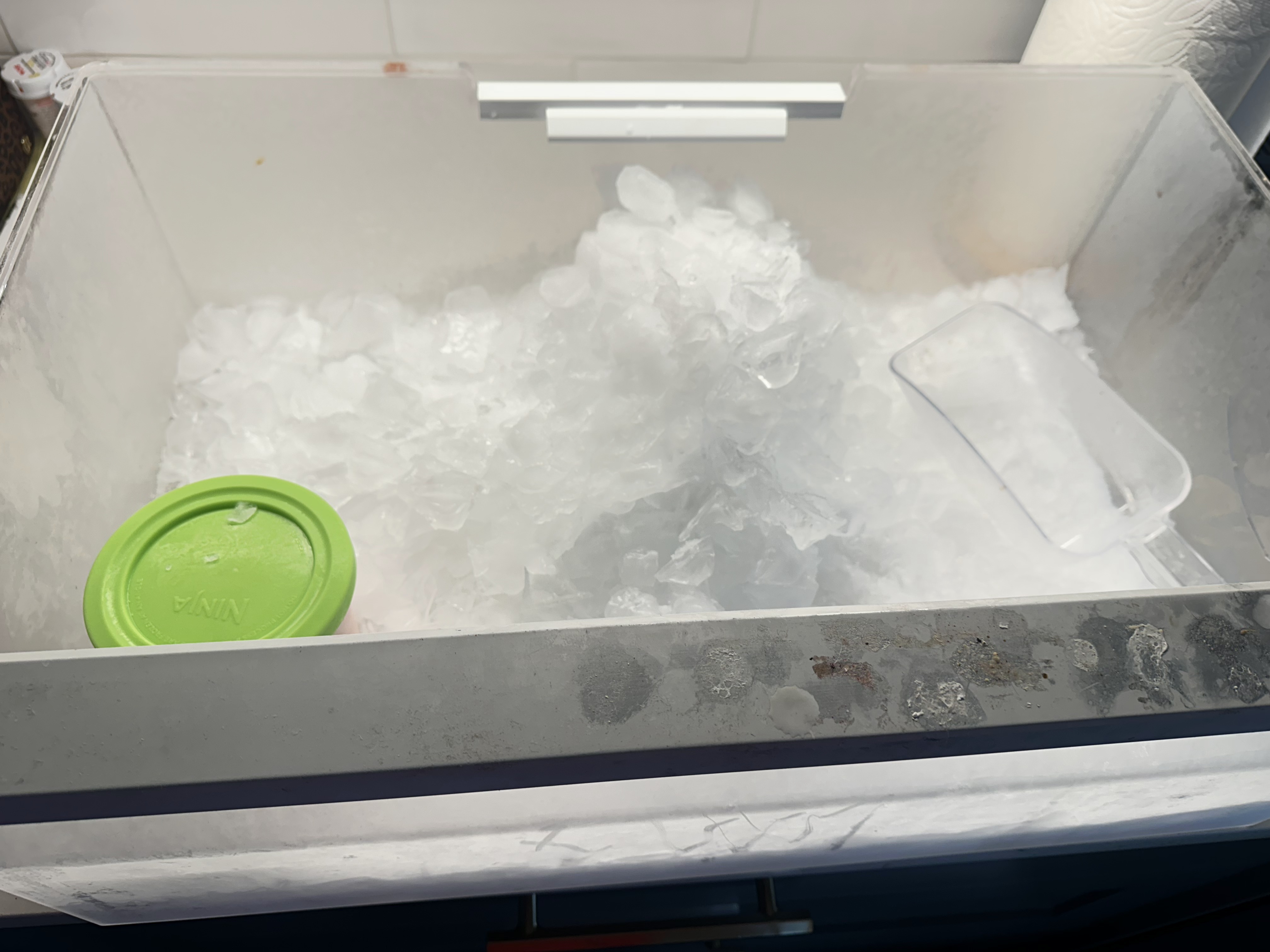 Excess ice accumulation inside Thermador refrigerator ice bin caused by ice maker cycling continuously.
