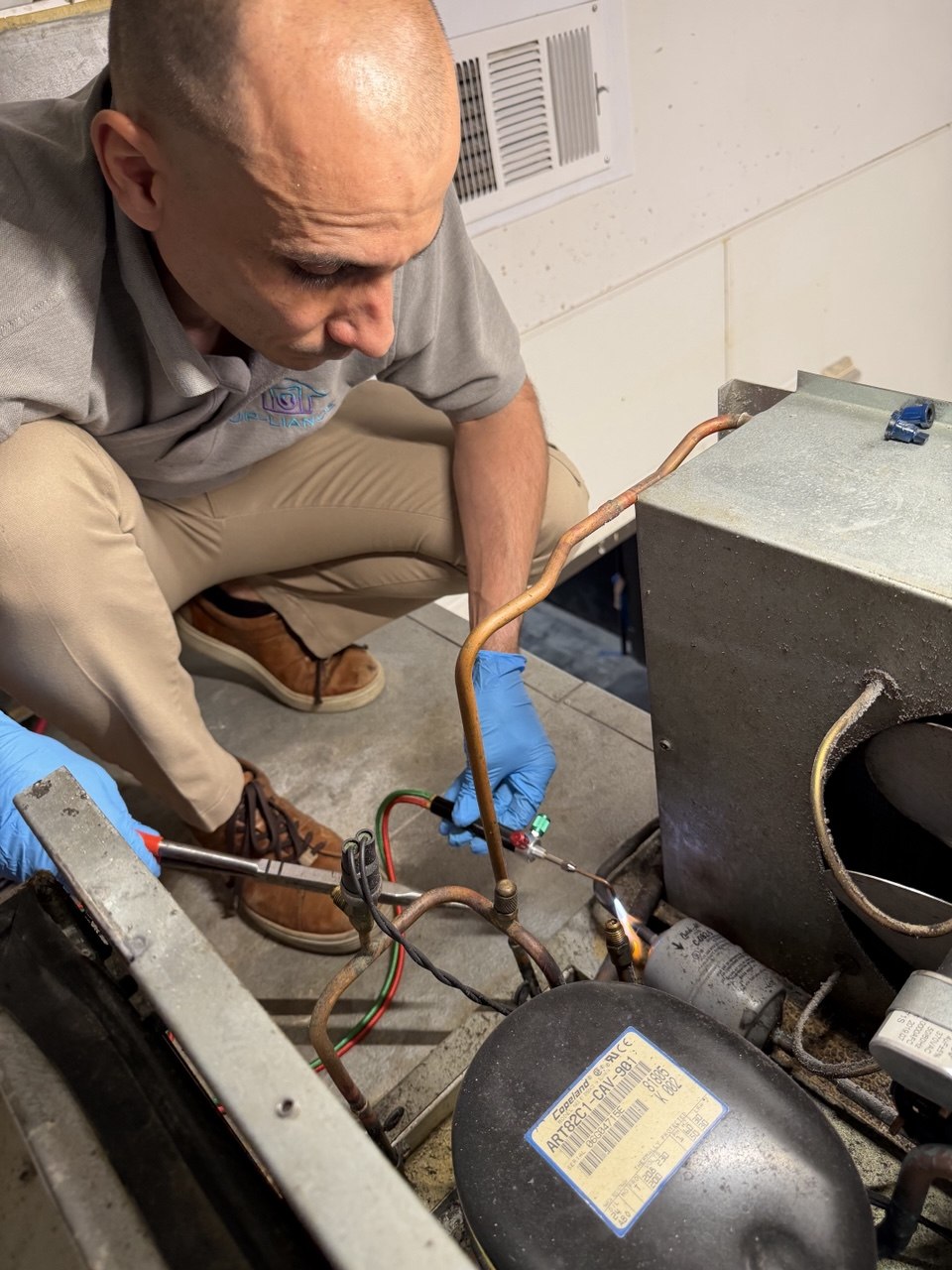 Up-liance Appliance Repair founder repairing a refrigerator